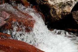 Rauschendes Wasser des Flusses Cians zwischen rotem Fels