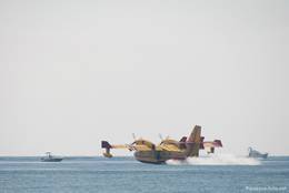Ein Löschflugzeug beim Wasser tanken im Mittelmeer, dazu muss der Pilot auch auf einige Boote aufpassen
